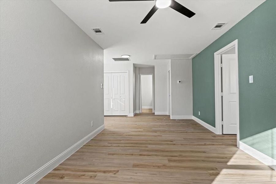 Empty room with ceiling fan and light hardwood / wood-style flooring