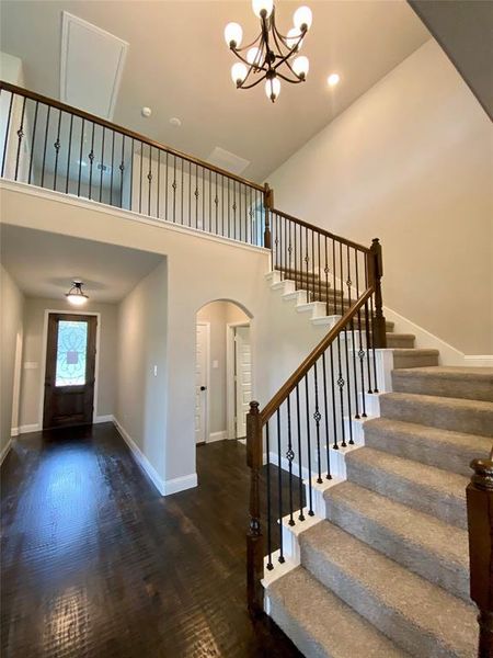 Impressive cathedral entry with wrought iron spindles on staircase and ORB chandelier