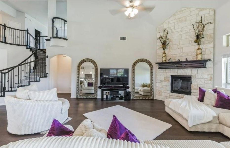 Living room featuring ceiling fan, high vaulted ceiling, and dark hardwood / wood-style flooring