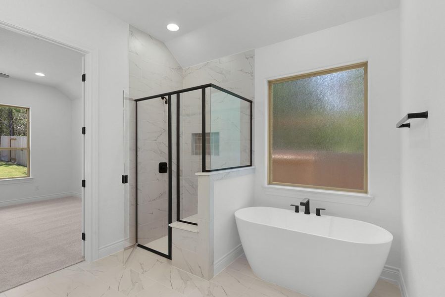 A bright bathroom with a spacious walk-in shower and a freestanding soaking tub.
