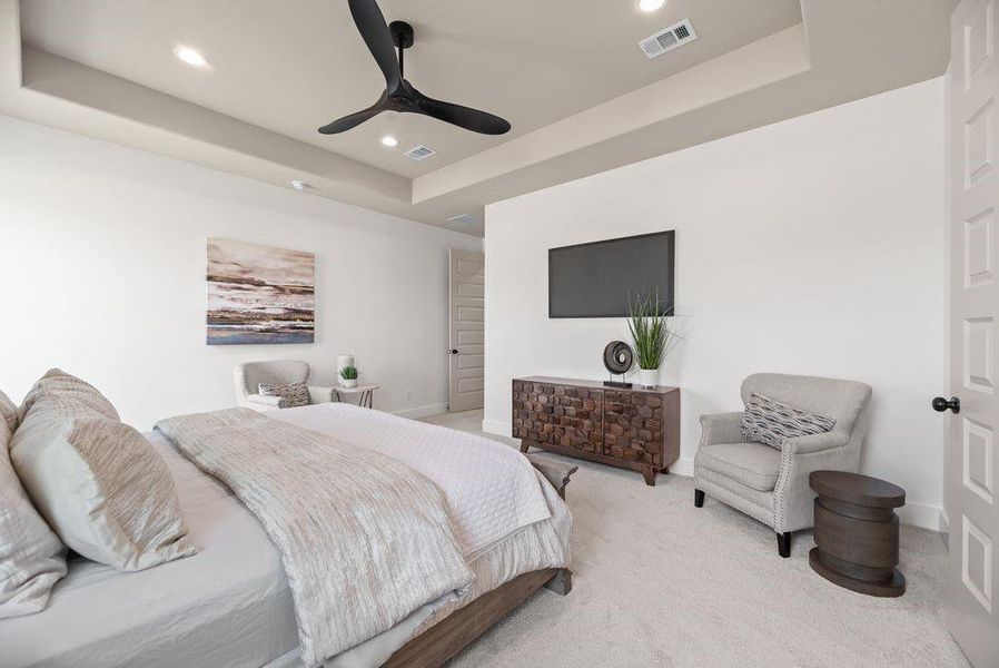 Carpeted bedroom with a raised ceiling, a ceiling fan, and recessed lighting Carpeted bedroom with a raised ceiling, a ceiling fan, and recessed lighting