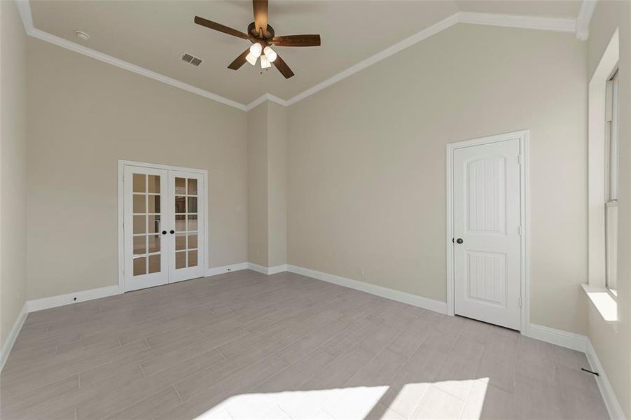 Unfurnished room featuring ceiling fan, ornamental molding, light hardwood / wood-style flooring, and french doors