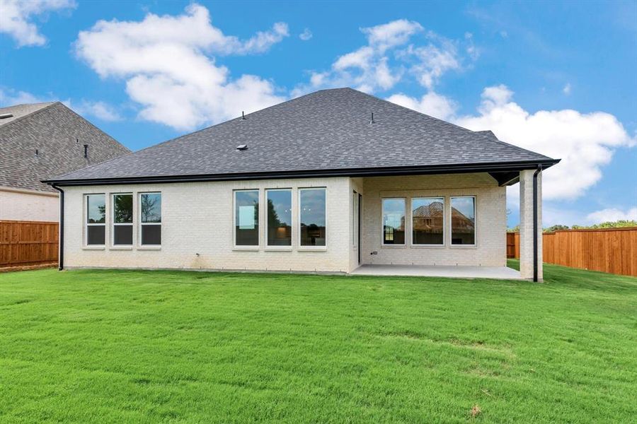 Rear view of property with a yard and a patio