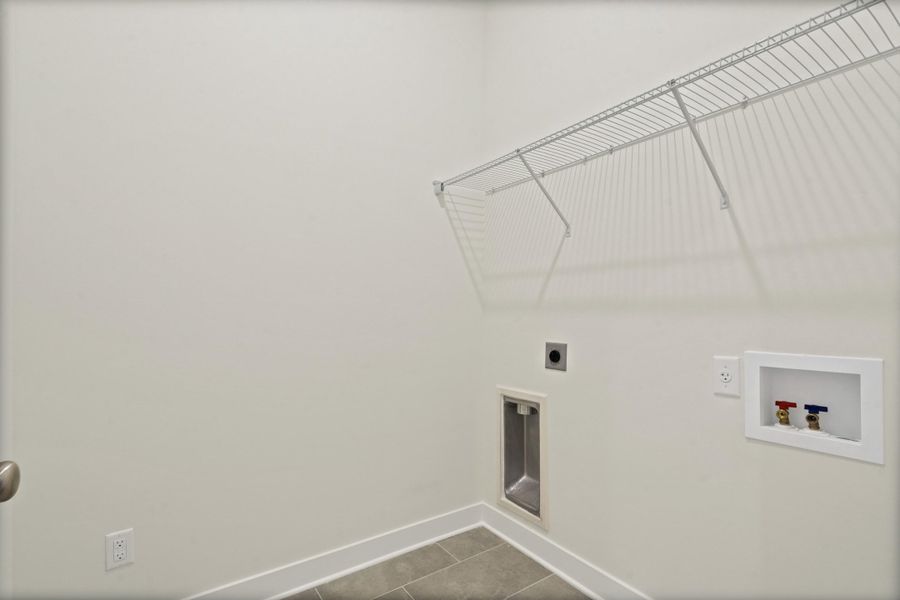 Laundry area featuring washer hookup, electric dryer hookup, and dark tile patterned flooring