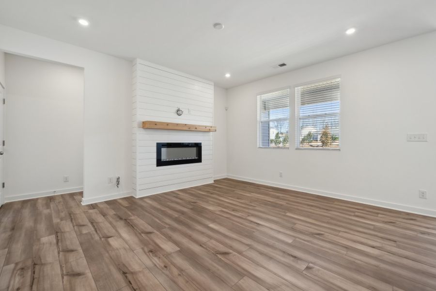 A room with a fireplace and a wood floor. A room with a fireplace and a wood floor.