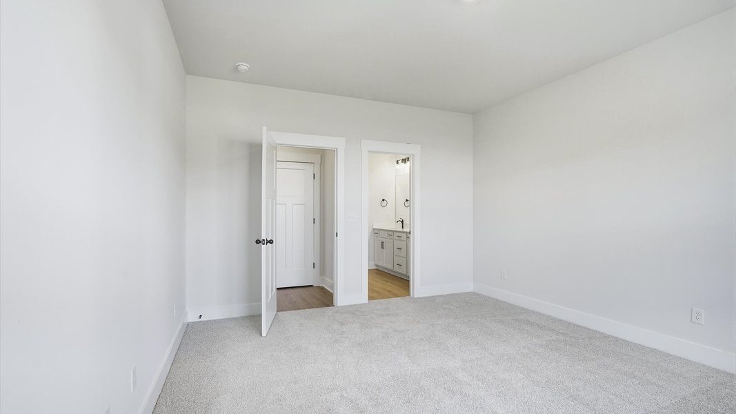Serene and stylish primary bedroom featuring carpet flooring and a thoughtful, modern layout near Downtown Fountain Inn