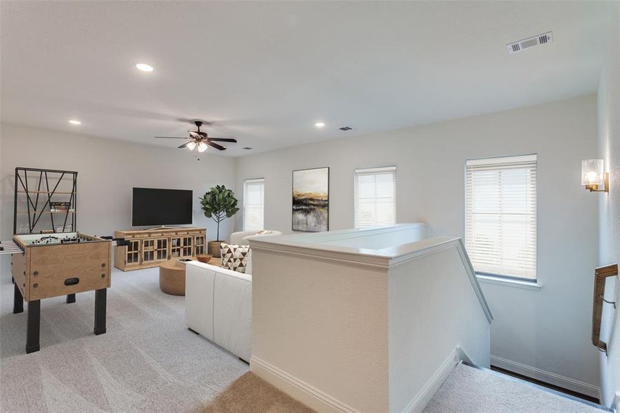 Living room with light colored carpet, ceiling fan, visible vents, and recessed lighting