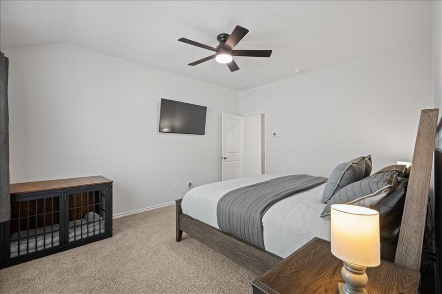 Carpeted bedroom featuring ceiling fan and lofted ceiling Carpeted bedroom featuring ceiling fan and lofted ceiling