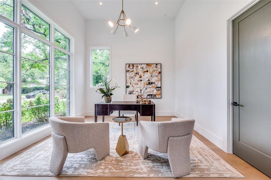 Office area with light hardwood / wood-style flooring, an inviting chandelier, and a healthy amount of sunlight