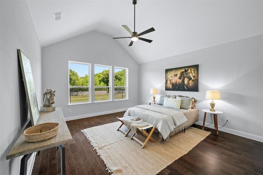 Bedroom featuring hardwood / wood-style flooring, lofted ceiling, and a ceiling fan