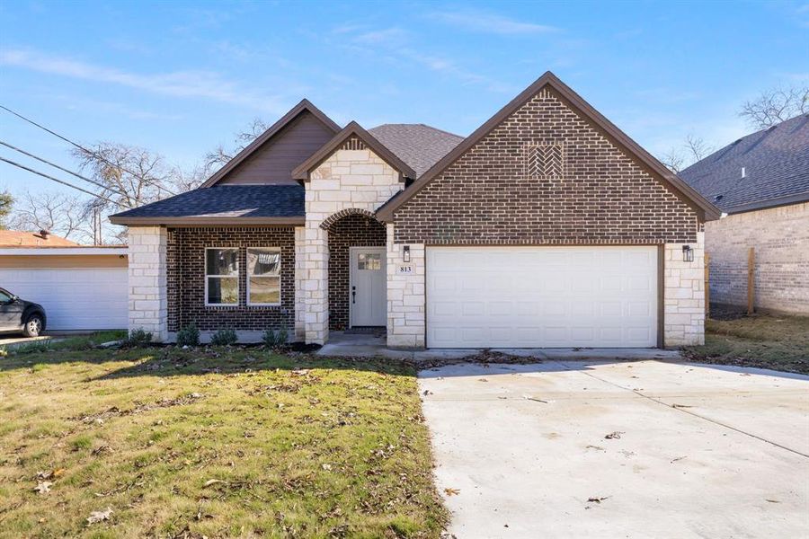 View of front of property with a front yard and a garage