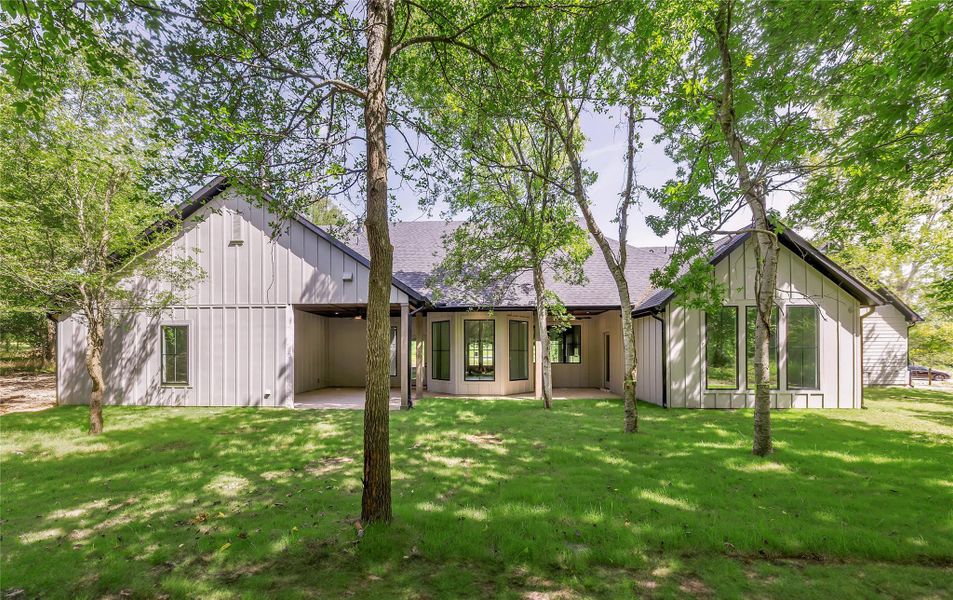 Rear view of house featuring a yard and board and batten siding