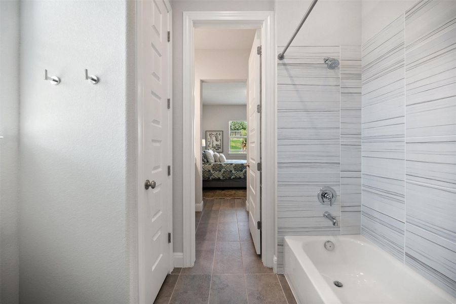 Bathroom with ensuite bathroom, shower / bathtub combination, and tile patterned floors