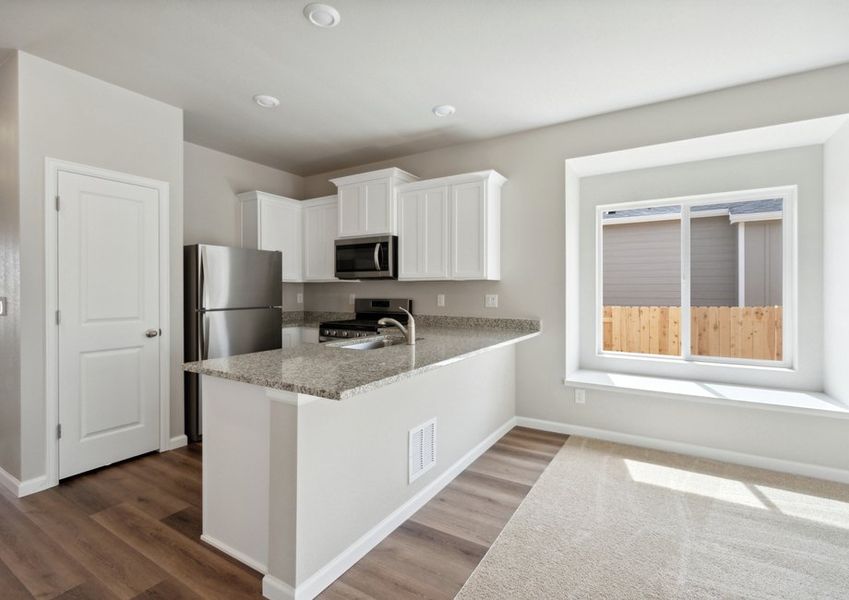 The kitchen has stainless steel appliances and plank flooring. The kitchen has stainless steel appliances and plank flooring.