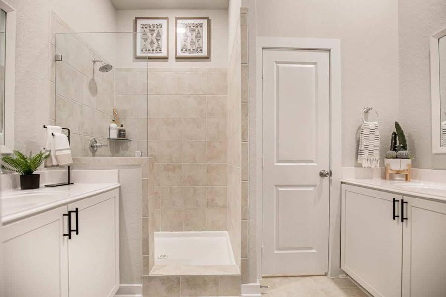Bathroom featuring two vanities and a walk in shower