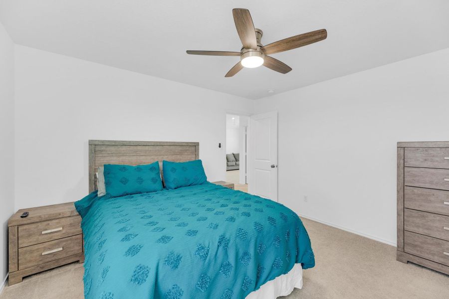 Carpeted bedroom featuring baseboards and ceiling fan