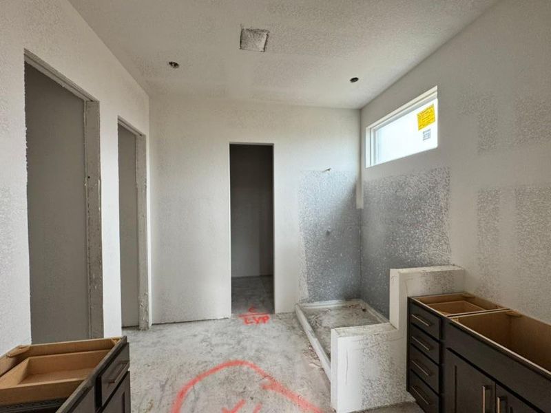 Bathroom featuring a stall shower, a textured ceiling, and a textured wall