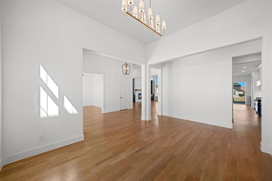 Unfurnished living room with a chandelier and wood finished floors Unfurnished living room with a chandelier and wood finished floors
