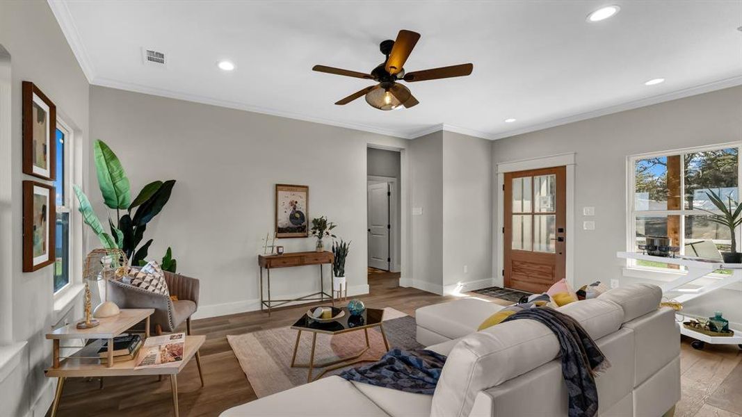 Living area with wood finished floors, a ceiling fan, crown molding, and recessed lighting