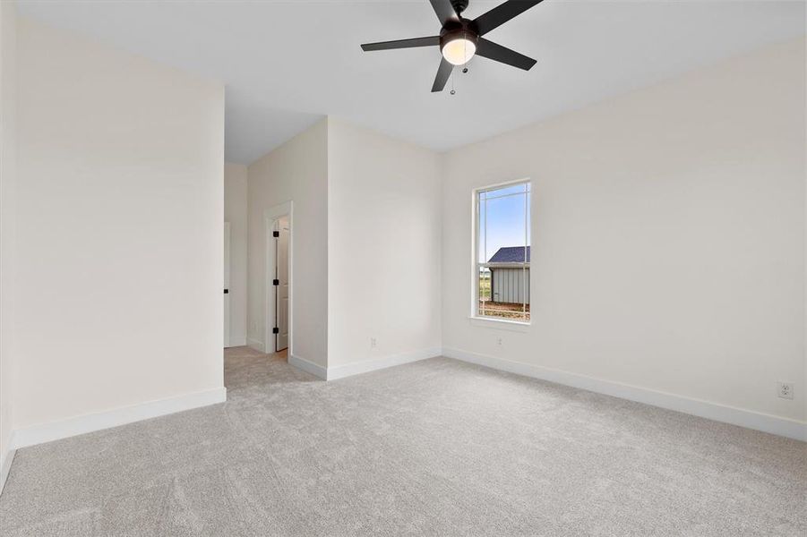 Unfurnished room with light colored carpet, a ceiling fan, and baseboards Unfurnished room with light colored carpet, a ceiling fan, and baseboards