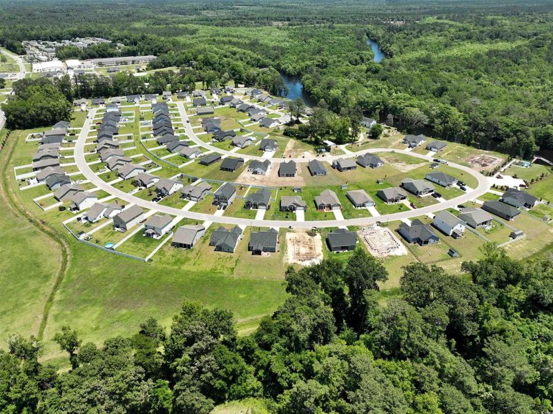 View of property location with a heavily wooded area and a nearby body of water