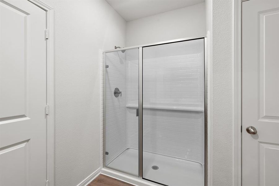 Bathroom featuring a stall shower and dark wood-style flooring