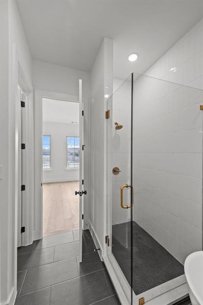 Bathroom with an enclosed shower and tile patterned flooring