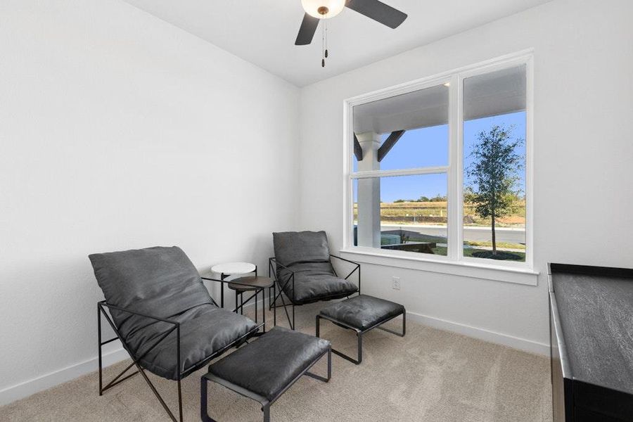 Living area with light colored carpet and a ceiling fan Living area with light colored carpet and a ceiling fan