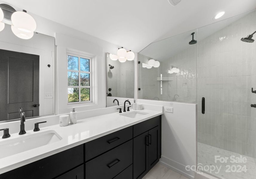 Luxurious primary bathroom with designer selections and dual sinks.