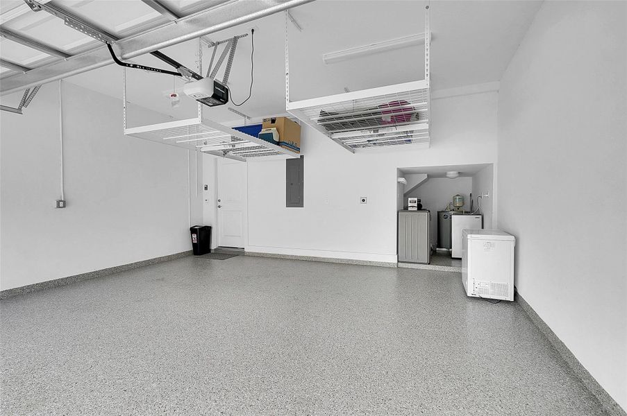 Two car garage with additional storage racks hung from ceiling.