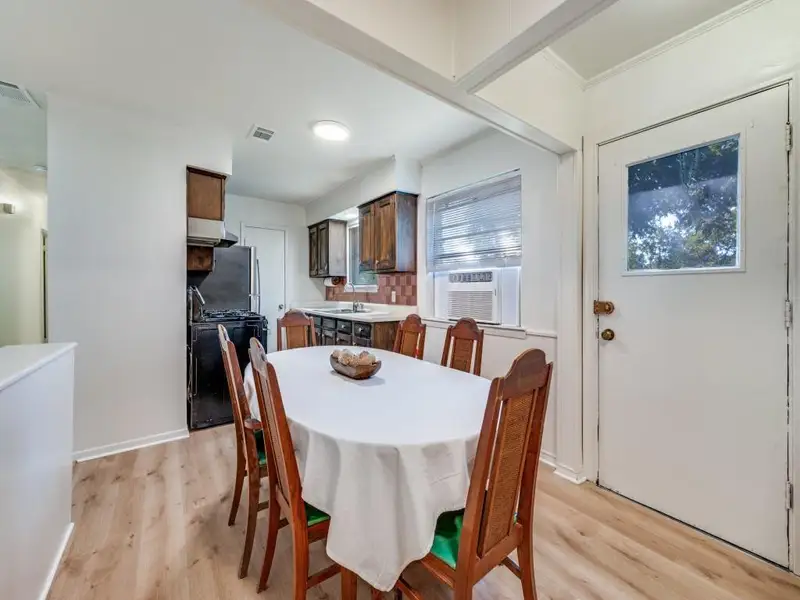 Dining space featuring light wood finished floors, crown molding, and cooling unit Dining space featuring light wood finished floors, crown molding, and cooling unit