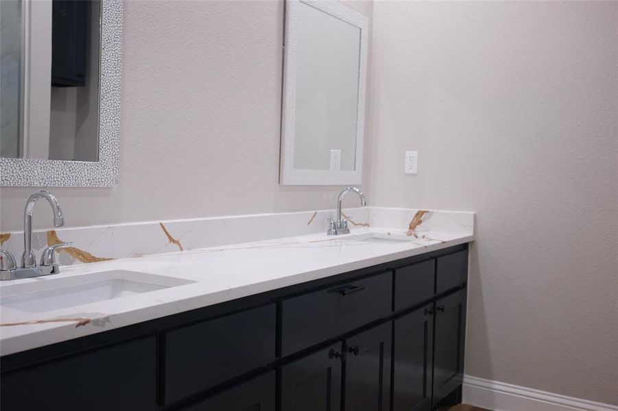 Full bathroom with double vanity and a textured wall Full bathroom with double vanity and a textured wall