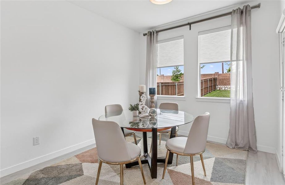 This dining area features a bright, neutral color palette and two windows providing views of the exterior
