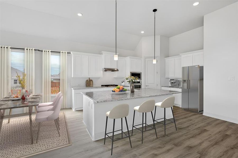 Kitchen featuring an island with sink, stainless steel appliances, white cabinets, and light hardwood / wood-style floors