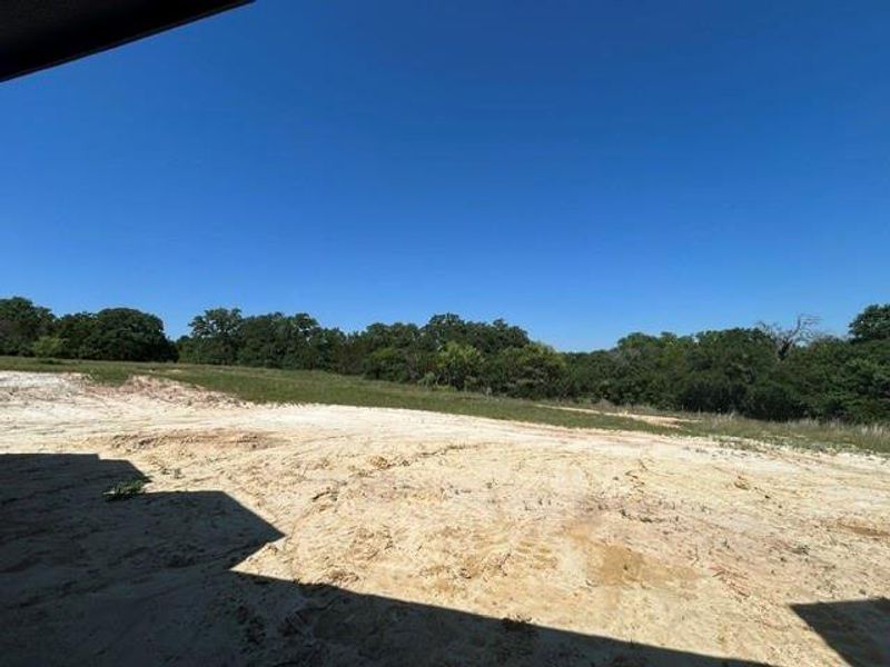 Expansive land parcel featuring clear skies and a distant tree line