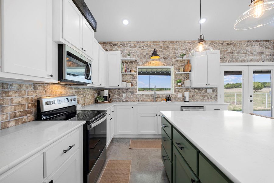 Kitchen featuring stainless steel appliances, two tone color scheme, open shelves, tasteful backsplash, and decorative light fixtures
