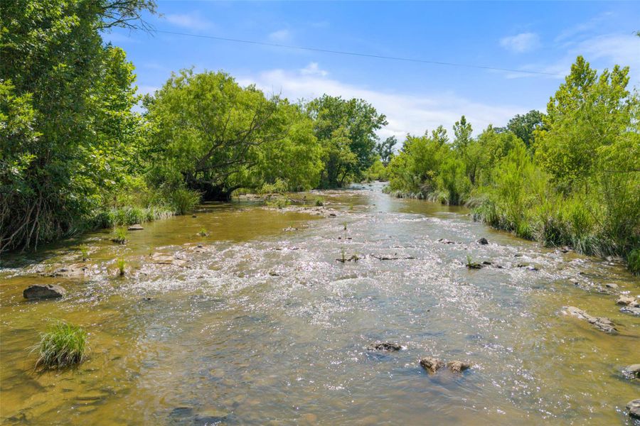 View of tree filled area featuring a water view