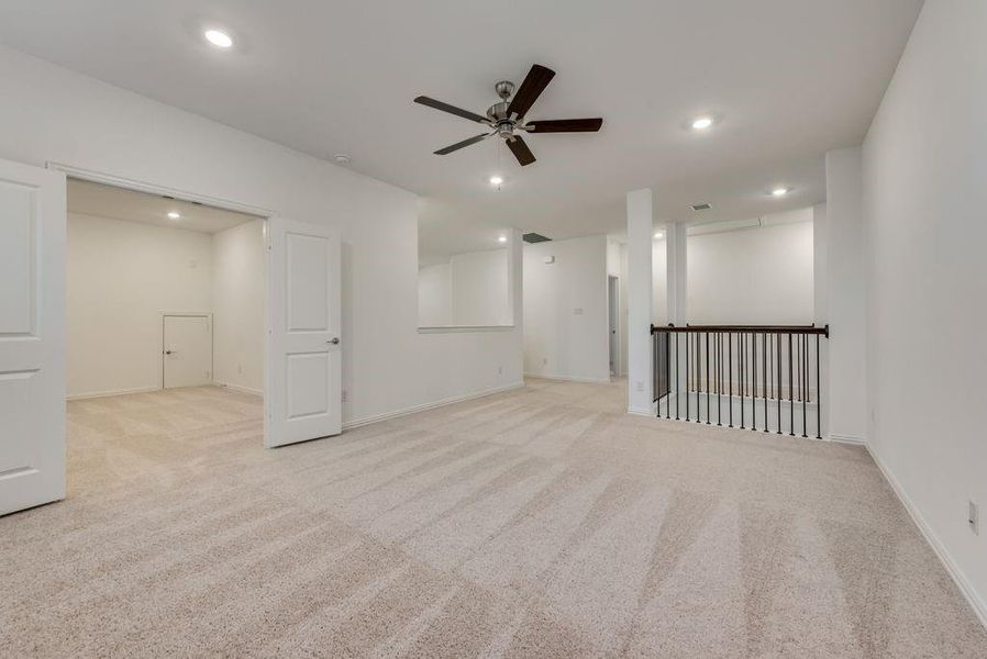 Basement featuring ceiling fan and light colored carpet