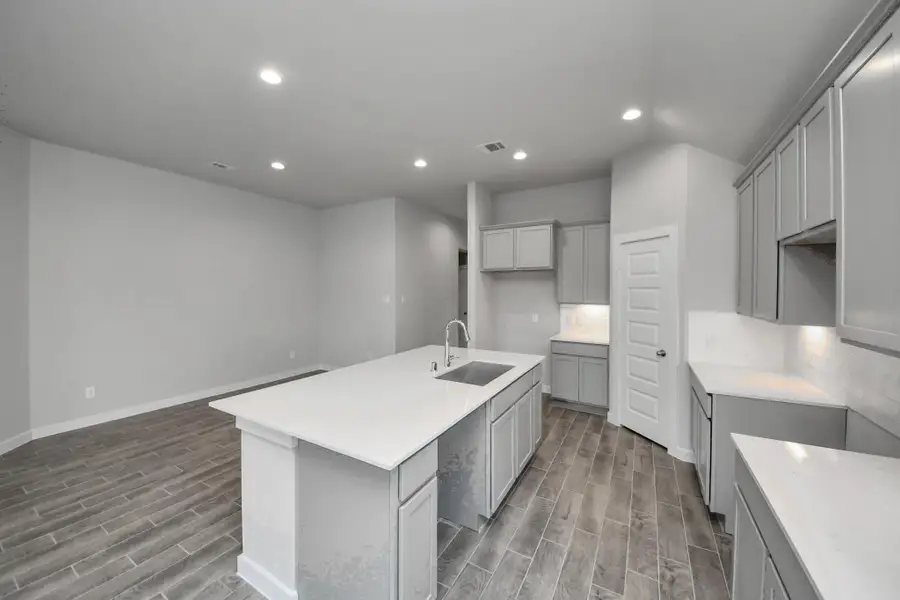 The open concept effortlessly connects the kitchen to the expansive family room, forming a perfect hub for gatherings. This seamless flow creates an inviting space where cooking and socializing come together harmoniously. Sample photo of completed home with similar floor plan. Actual colors and selections may vary. The open concept effortlessly connects the kitchen to the expansive family room, forming a perfect hub for gatherings. This seamless flow creates an inviting space where cooking and socializing come together harmoniously. Sample photo of completed home with similar floor plan. Actual colors and selections may vary.