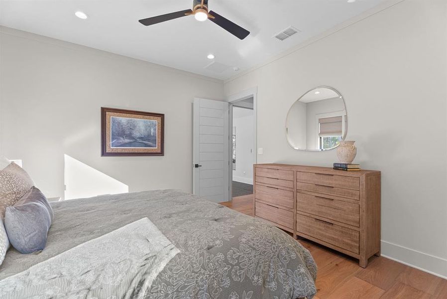 Bedroom featuring light wood-style flooring, a ceiling fan, crown molding, and recessed lighting