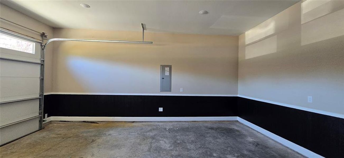 Garage featuring electric panel and wainscoting Garage featuring electric panel and wainscoting