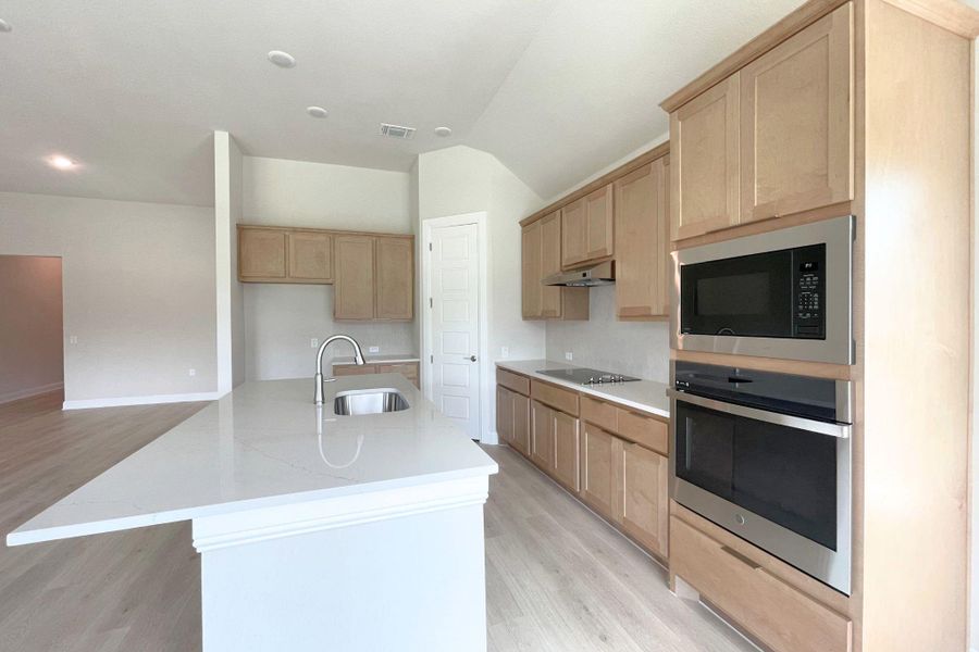 Culinary delights await in this bright, well-appointed kitchen featuring a substantial island and sleek integrated appliances.