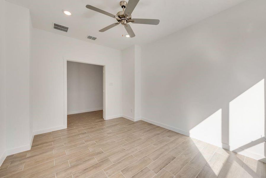 Empty room featuring a ceiling fan, light wood-type flooring, and recessed lighting