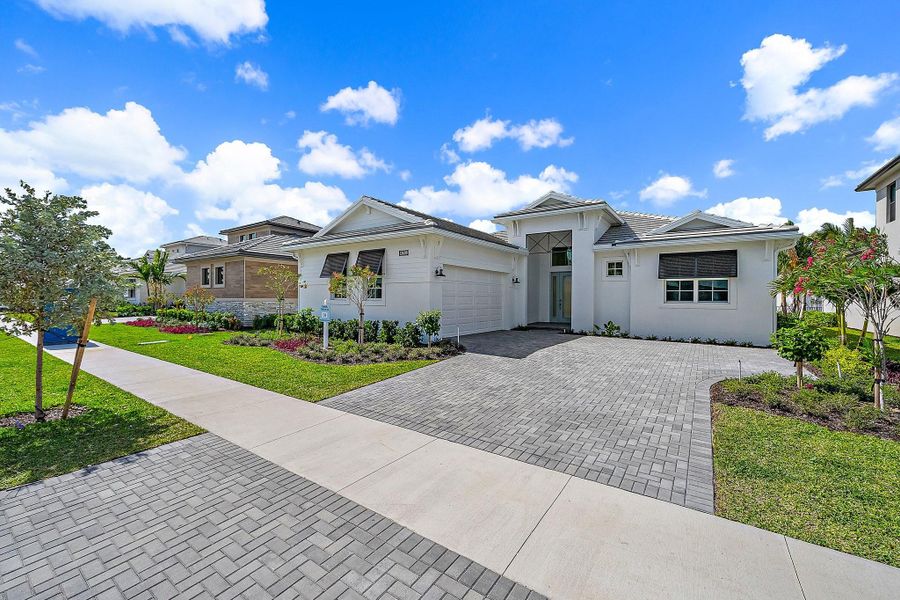 Front exterior of a new home in L'Ambiance at Avenir, Palm Beach Gardens, FL, highlighting curb appeal (Image 22).