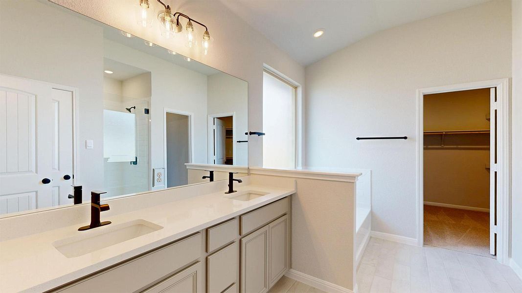 Full bathroom with a walk in closet, double vanity, a shower stall, lofted ceiling, and a garden tub Full bathroom with a walk in closet, double vanity, a shower stall, lofted ceiling, and a garden tub