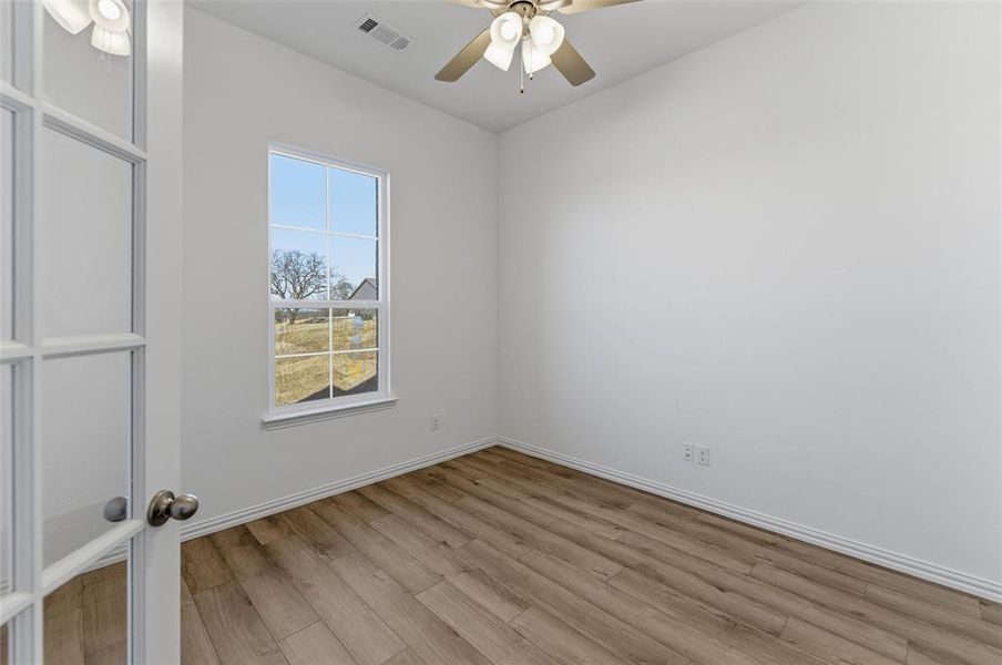Empty room featuring light wood finished floors and a ceiling fan