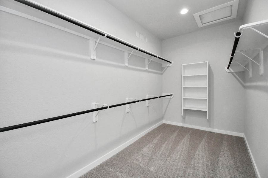 Walk-in closet that epitomizes luxury and practicality. This generously sized space features built-in shelving, offering abundant room for impeccable organization. High ceilings and recessed lighting create a bright and welcoming ambiance. Sample photo of completed home with similar floor plan. Actual colors and selections may vary. Walk-in closet that epitomizes luxury and practicality. This generously sized space features built-in shelving, offering abundant room for impeccable organization. High ceilings and recessed lighting create a bright and welcoming ambiance. Sample photo of completed home with similar floor plan. Actual colors and selections may vary.