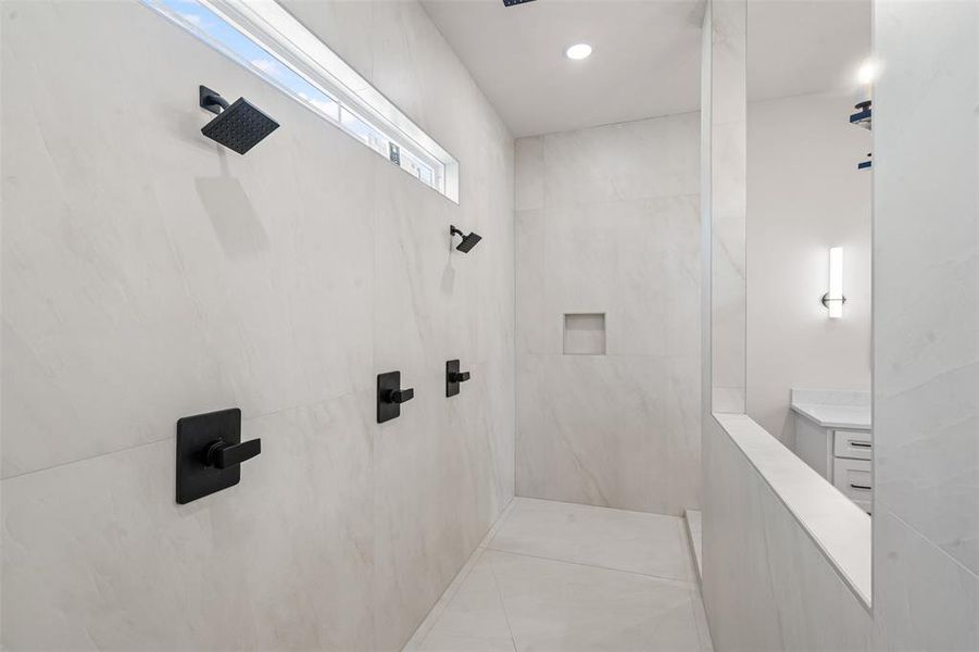 Bathroom featuring a marble finish shower, light tile patterned flooring, and recessed lighting Bathroom featuring a marble finish shower, light tile patterned flooring, and recessed lighting
