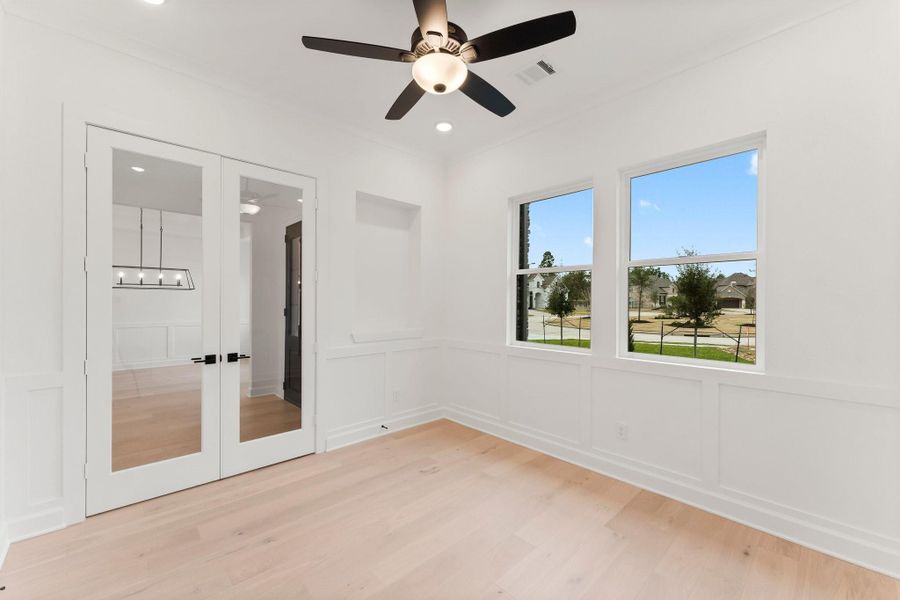 Bright study features a ceiling fan and glass double doors, offering a modern and inviting space. Bright study features a ceiling fan and glass double doors, offering a modern and inviting space.