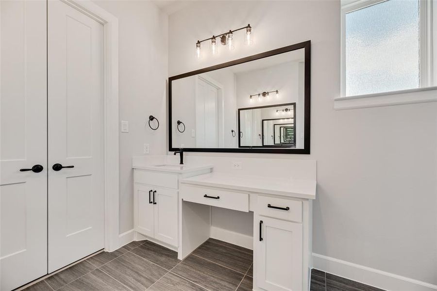 Full bath featuring vanity and baseboards